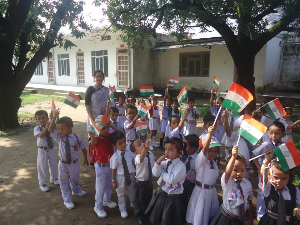 Pre-primary students at Nanda Convent School waving the Indian flag